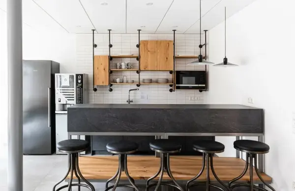 Moderne Küche mit Kücheninsel, Holzregalen, Hockern und Edelstahlgeräten.