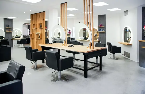 Moderner Friseursalon mit stilvollen Spiegeln, Friseurstühlen und hellem Interieur.