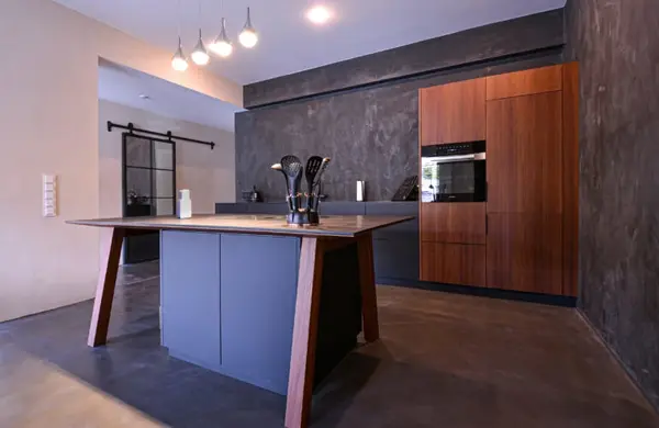 Moderne Designküche mit Kücheninsel, Holzfronten und dunkler Wand für stilvolles Wohnen.